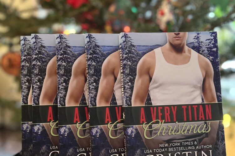 Several paperback copies of A VERY TITAN CHRISTMAS in front of a Christmas tree